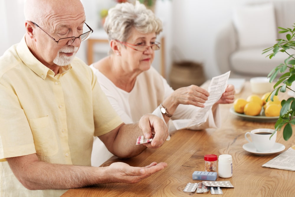 elderly couple counting pills